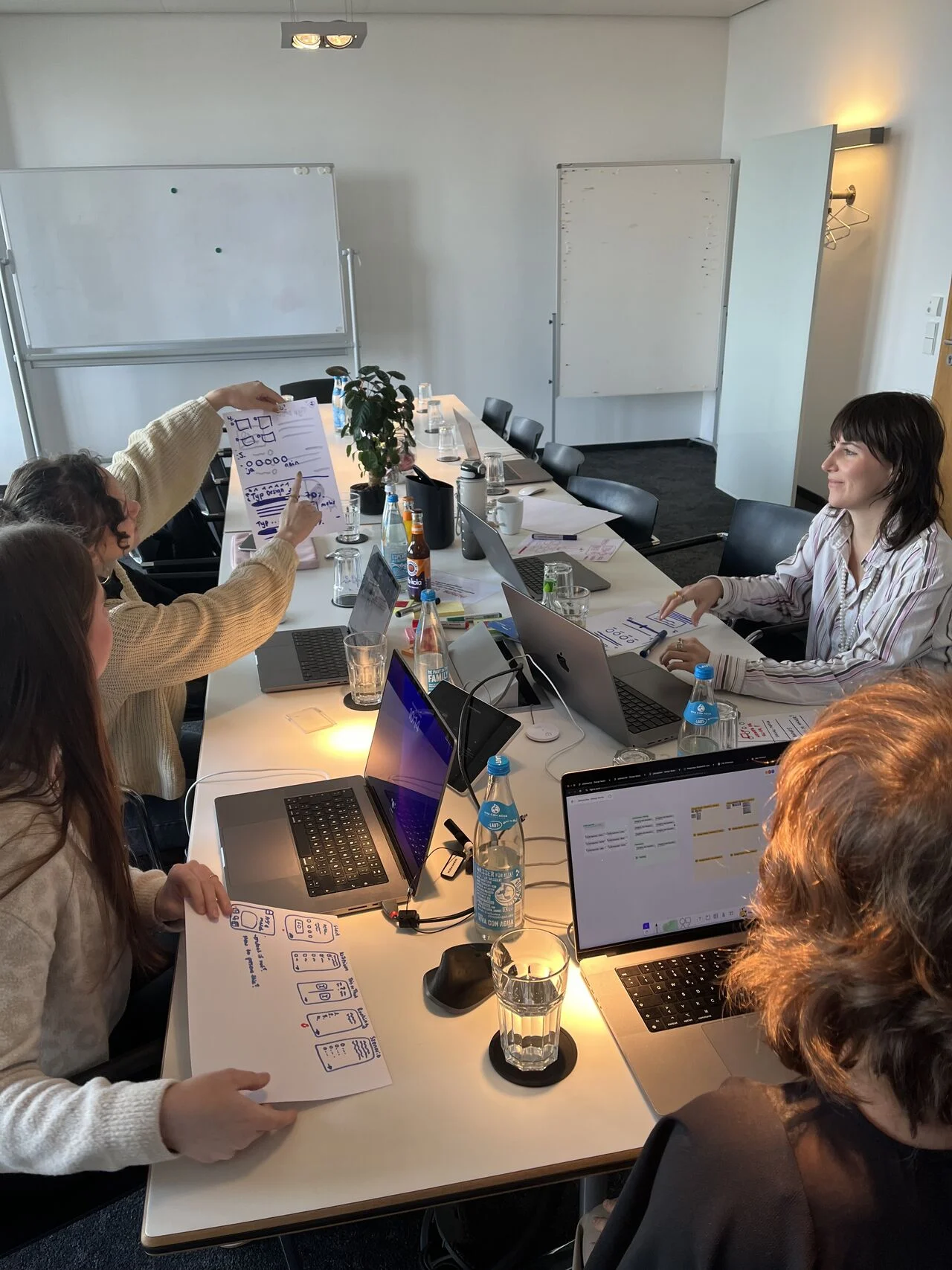 Team discussing sketches around the meeting table